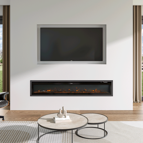 Recessed electric fireplace with glowing orange flames, seamlessly integrated into a minimalist white wall below a built-in TV, paired with a modern round coffee table and natural light from large windows.